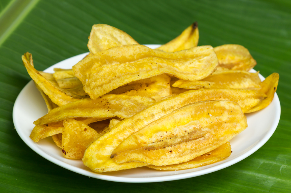 Fried,Banana,Chips,On,White,Plate,With,Banana,Leaf,Background.